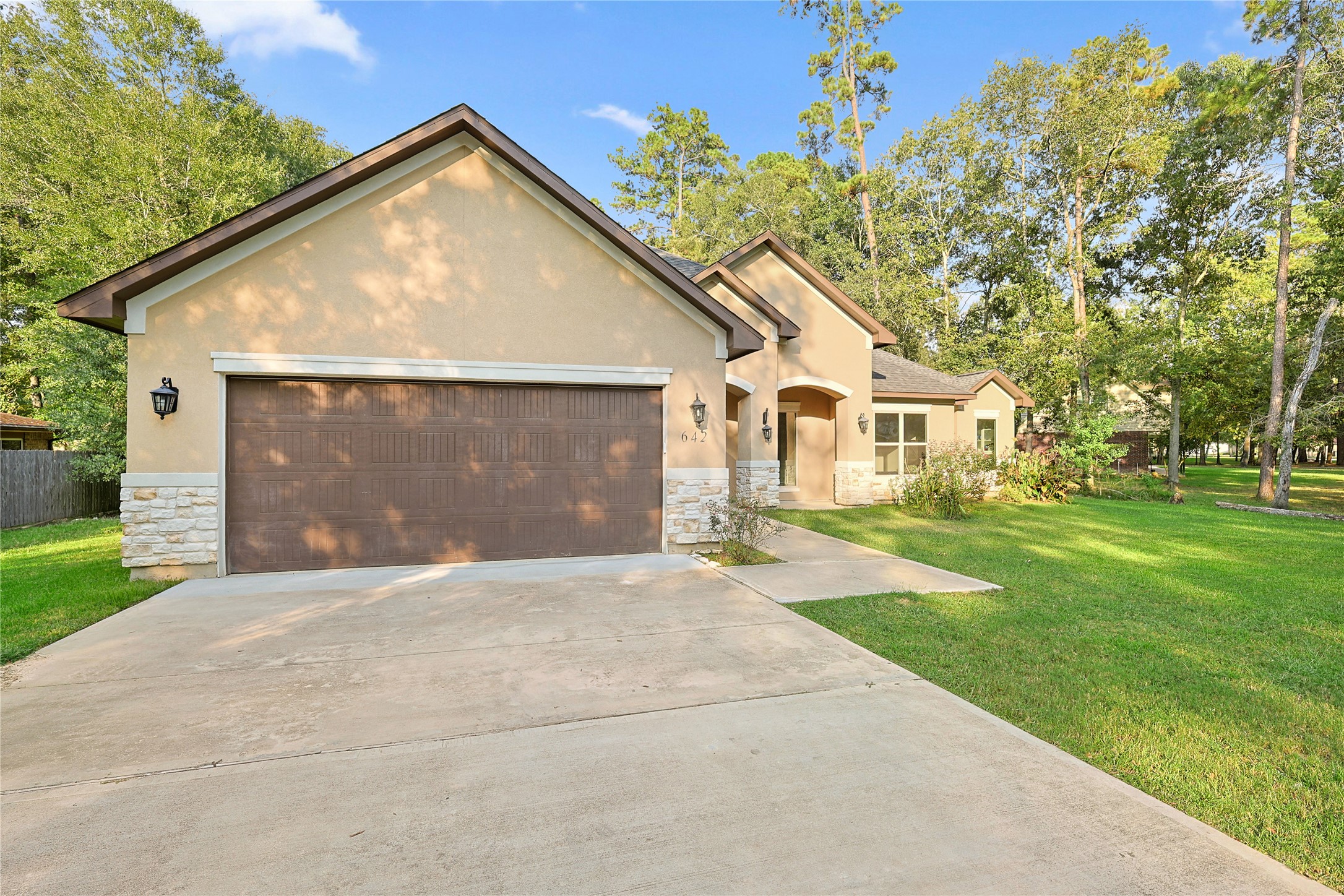 642 Parthenon Place New Caney, TX 77357 - Photo 2 of 30 a front view of a house with a yard and garage