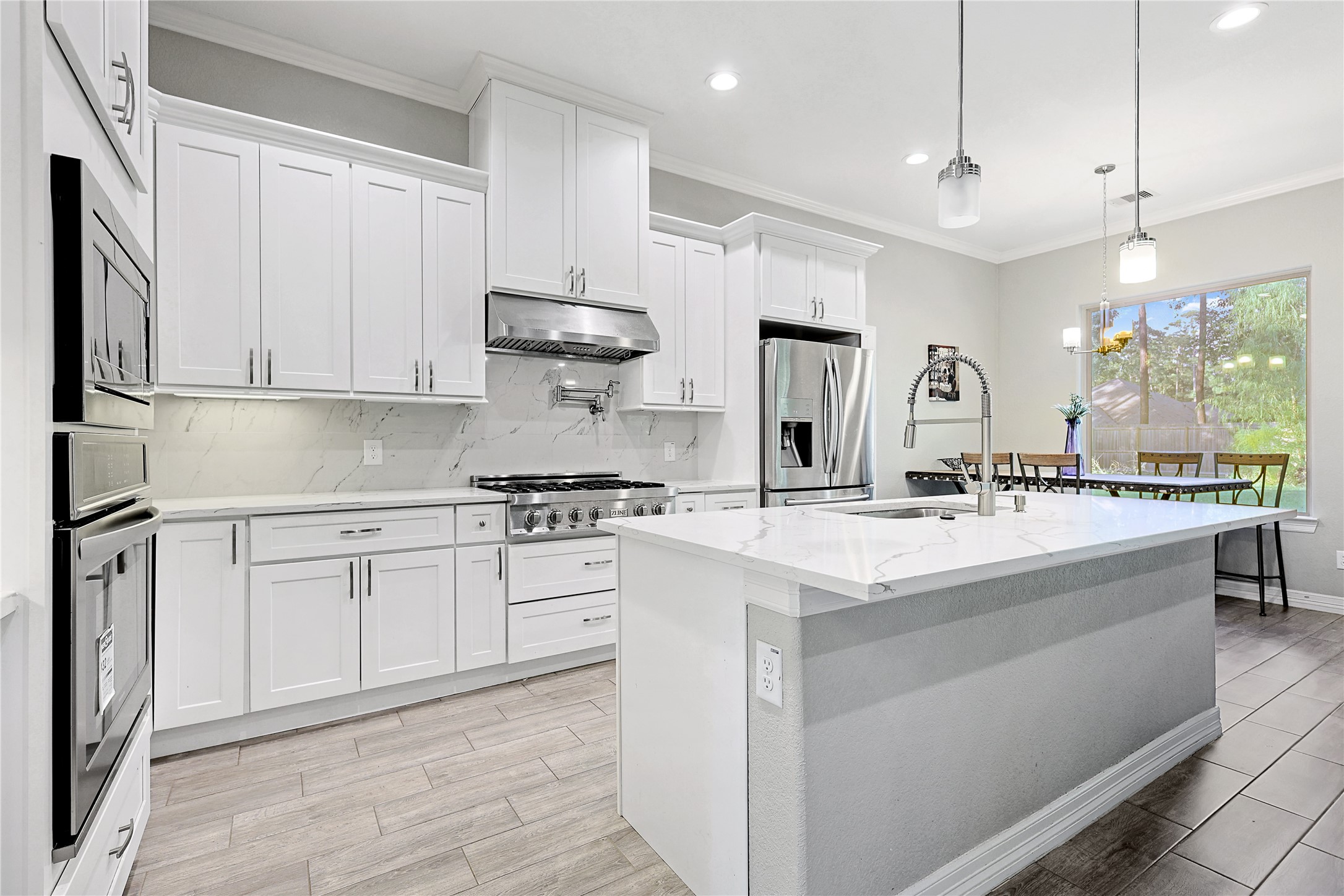 642 Parthenon Place New Caney, TX 77357 - Photo 6 of 30 a kitchen with kitchen island granite countertop a sink appliances cabinets and a counter top space