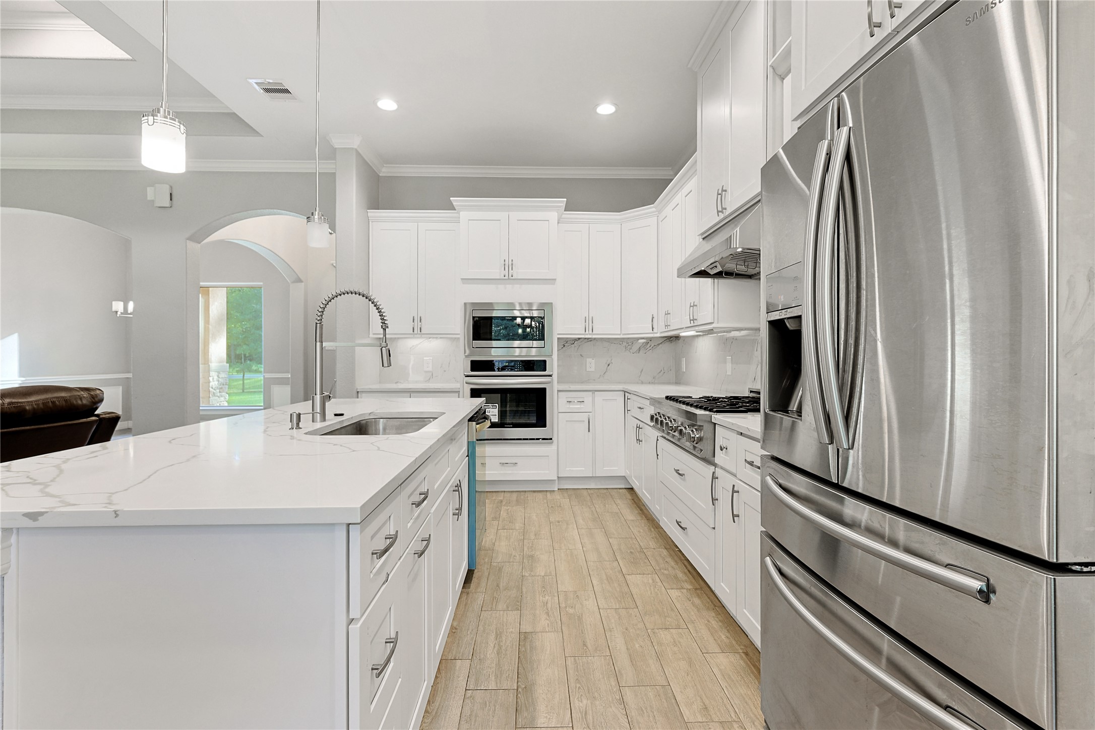 642 Parthenon Place New Caney, TX 77357 - Photo 9 of 30 a large white kitchen with stainless steel appliances a sink and a refrigerator