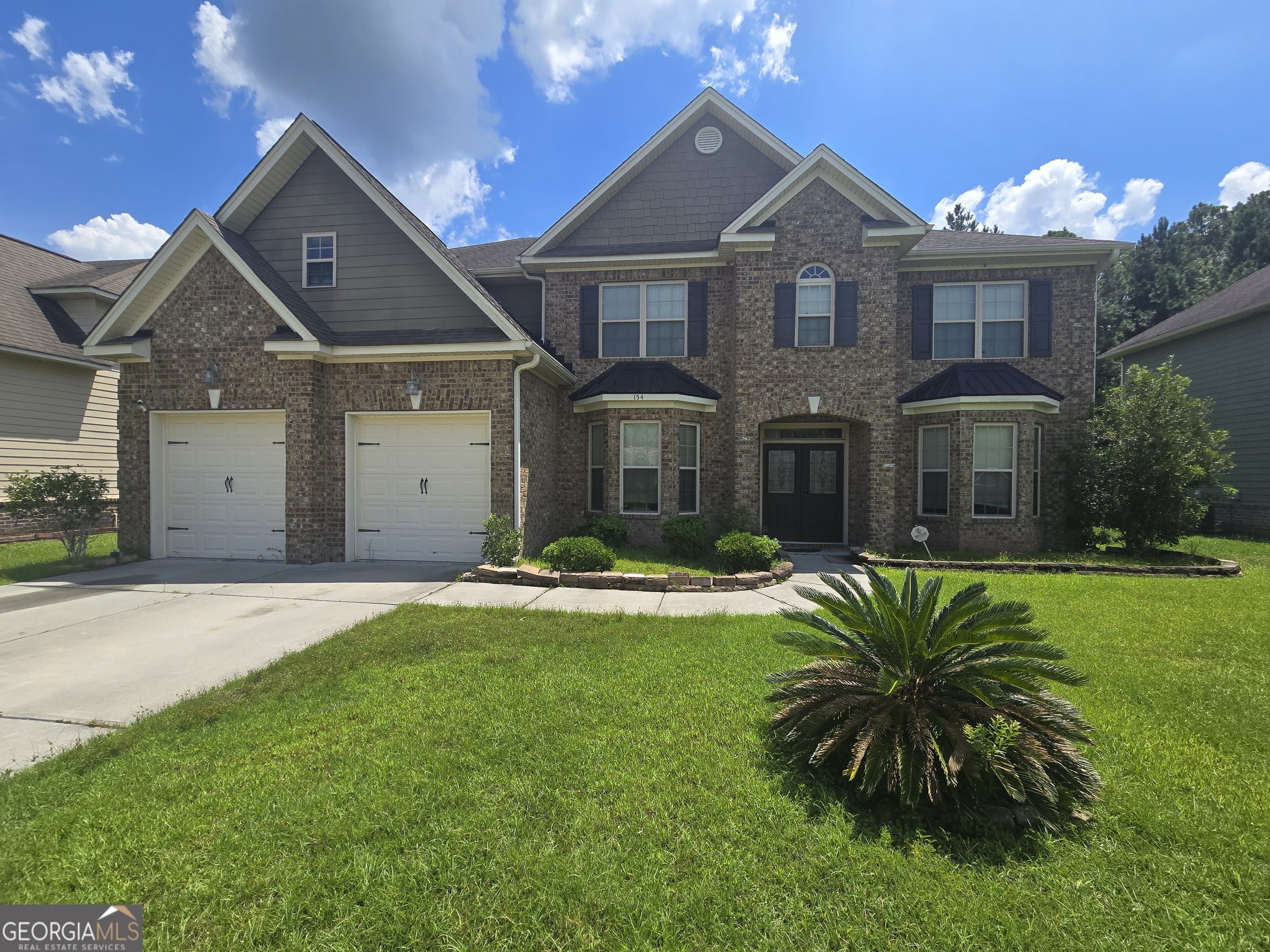 a front view of a house with a garden and yard