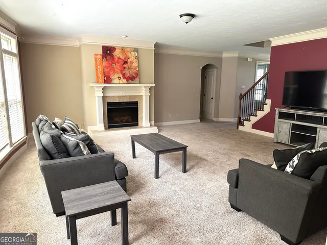 a living room with furniture a flat screen tv and a fireplace