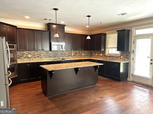 a kitchen with kitchen island granite countertop wooden cabinets and a granite counter tops