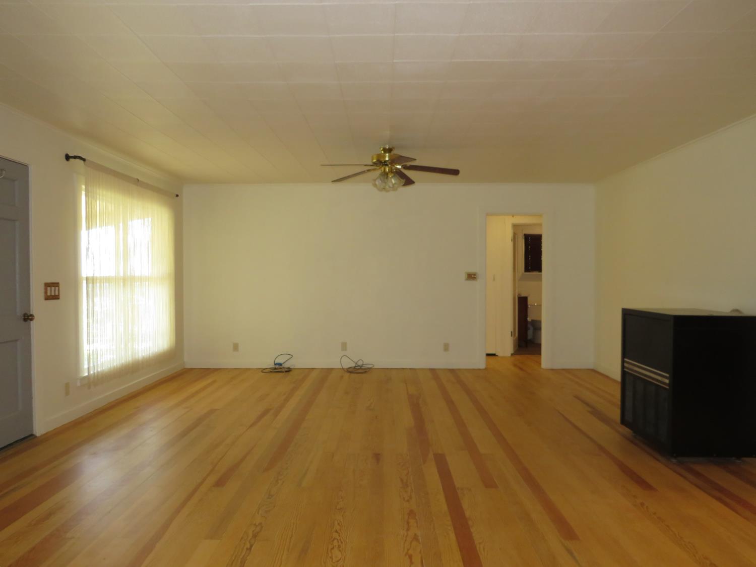 320 Pleasant Street Colfax, CA 95713 - Photo 12 of 49 a view of empty room with a fireplace and wooden floor