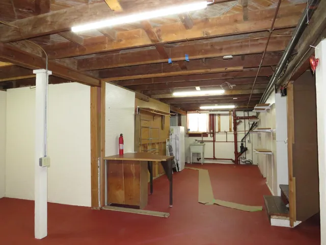a view of a refrigerator in kitchen and an empty room