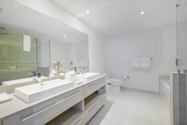a bathroom with a double vanity sink toilet and mirror