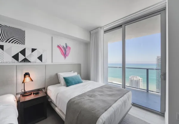 a bedroom with a large bed and a chandelier