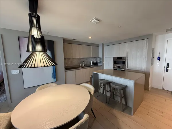 a kitchen with kitchen island a appliances a sink a counter space and wooden floor