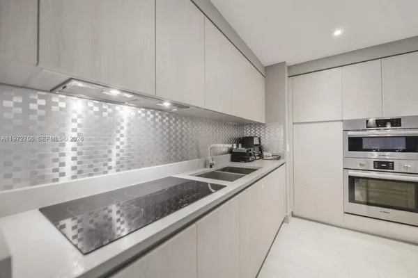 a kitchen with stainless steel appliances granite countertop a sink and a white cabinets