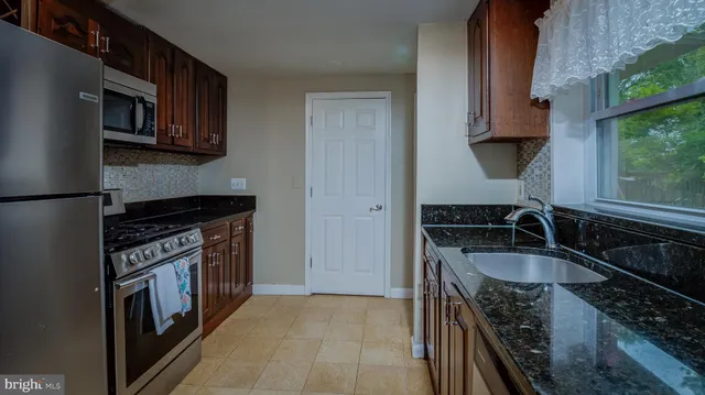 a kitchen with granite countertop a stove and a sink