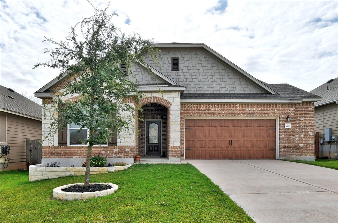 a front view of a house with a yard and garage