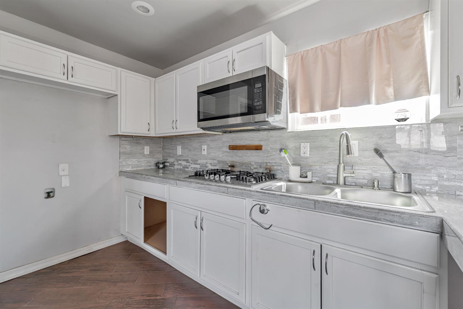 536 Locust Street Lodi, CA 95240 - Photo 7 of 18 a kitchen with granite countertop white cabinets and white appliances