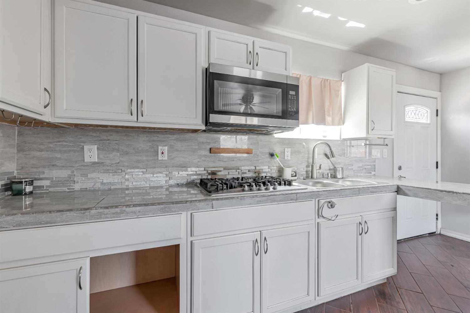536 Locust Street Lodi, CA 95240 - Photo 8 of 18 a kitchen with white cabinets stainless steel appliances and sink