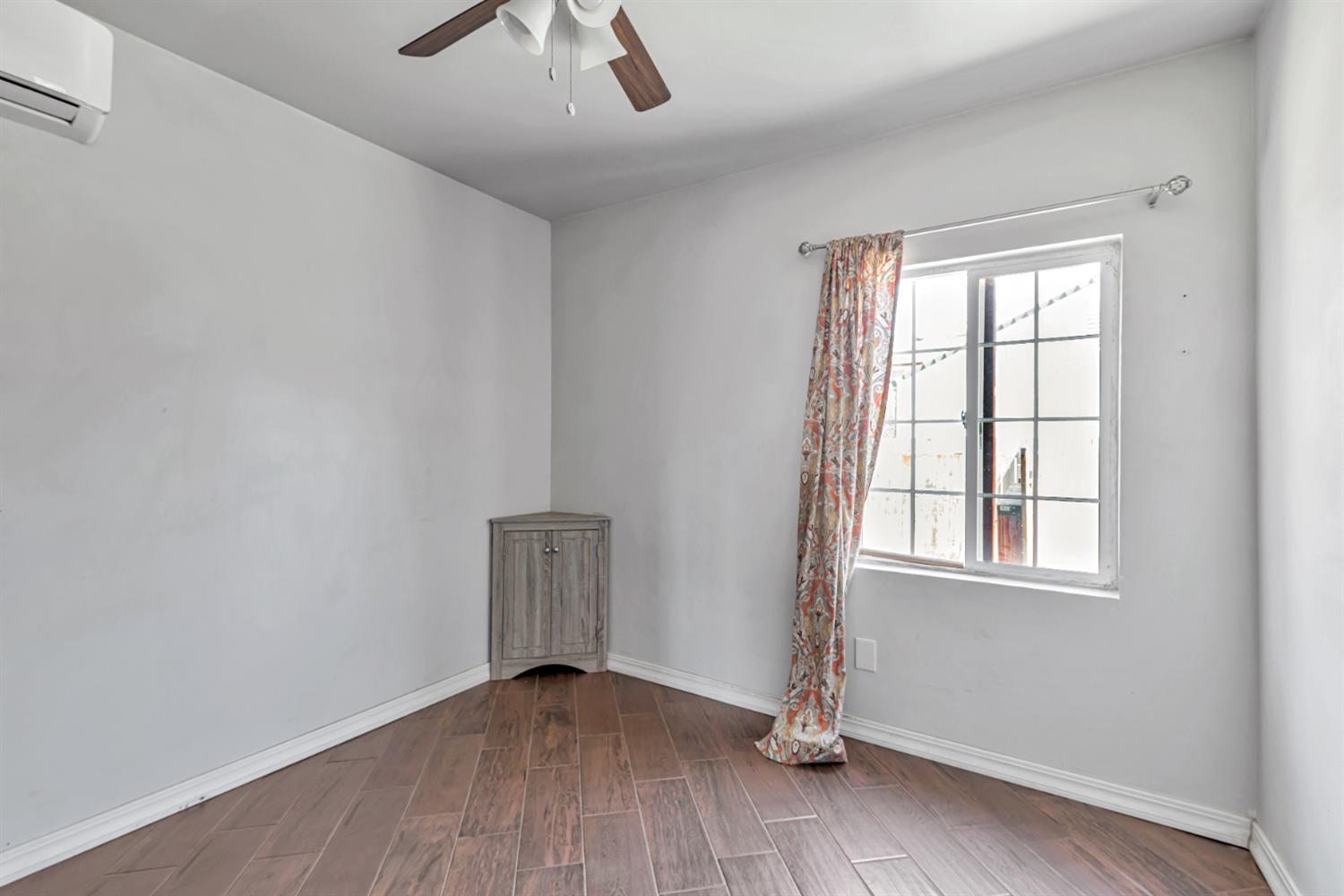 536 Locust Street Lodi, CA 95240 - Photo 10 of 18 an empty room with wooden floor chandelier fan and windows