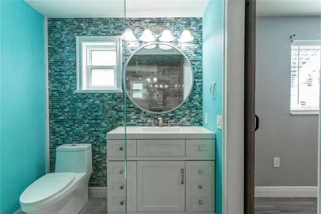 a bathroom with a toilet a sink and mirror