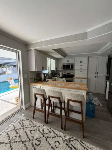 a kitchen with a refrigerator stove and white cabinets
