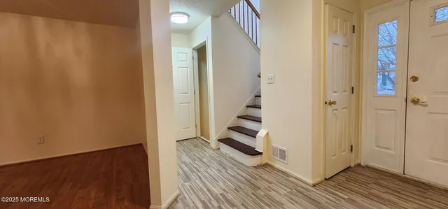 a view of a room with wooden floor and white walls