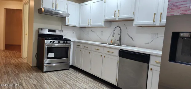 a kitchen with granite countertop a sink and a stove top oven