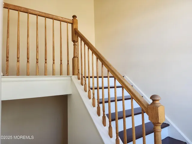 a view of staircase with railing and white walls