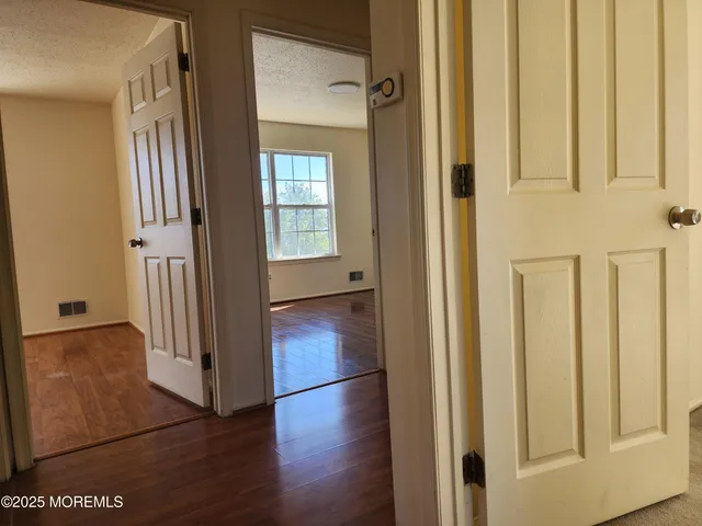 a view of a hallway with wooden floor and staircase