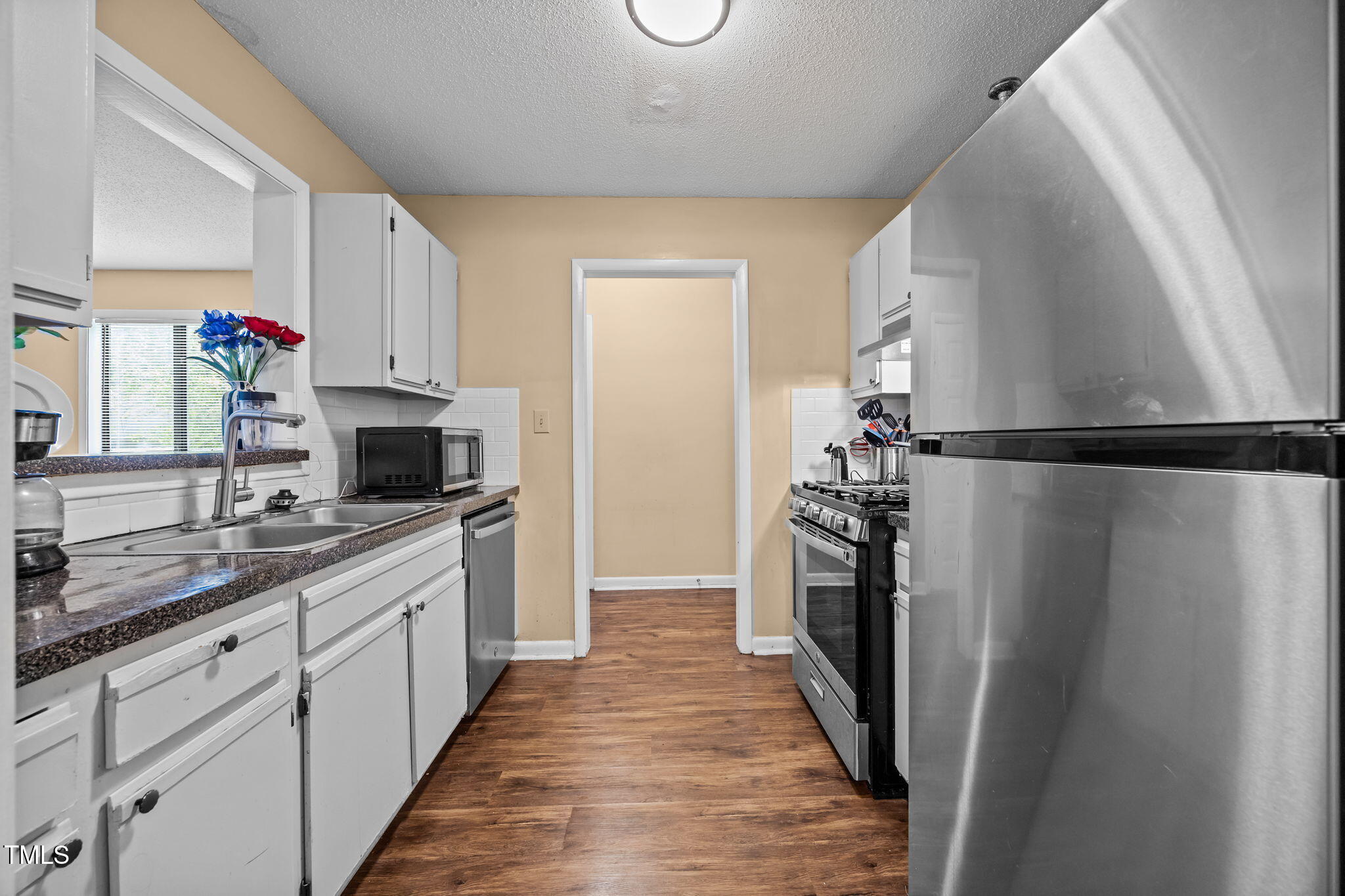 5816 Pointer Drive, Unit 102 Raleigh, NC 27609 - Photo 15 of 25 a kitchen with white cabinets and stainless steel appliances