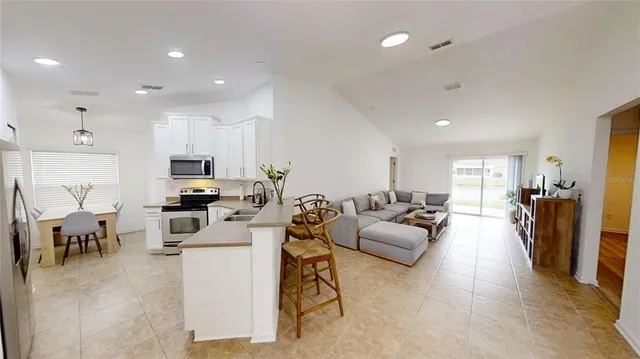 a living room kitchen with furniture and a wooden floor