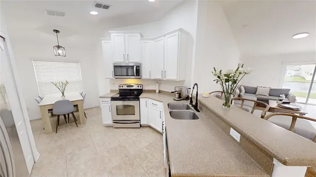 a large white kitchen with stainless steel appliances