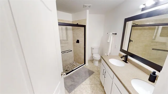 a bedroom with a bed and a flat tv screen on dresser