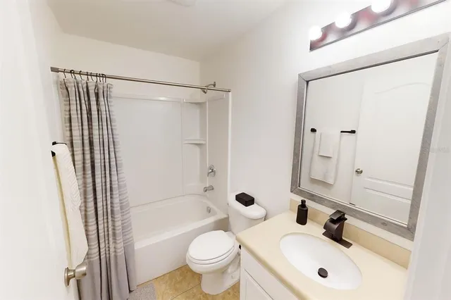 a bathroom with a sink a toilet and shower curtain
