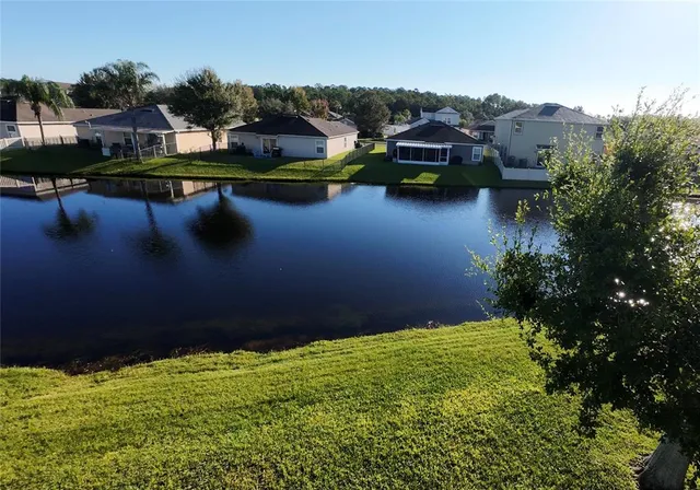 an aerial view of a house with a garden and lake view