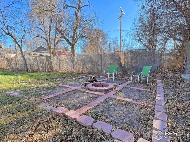 a view of a backyard with furniture and a fire pit