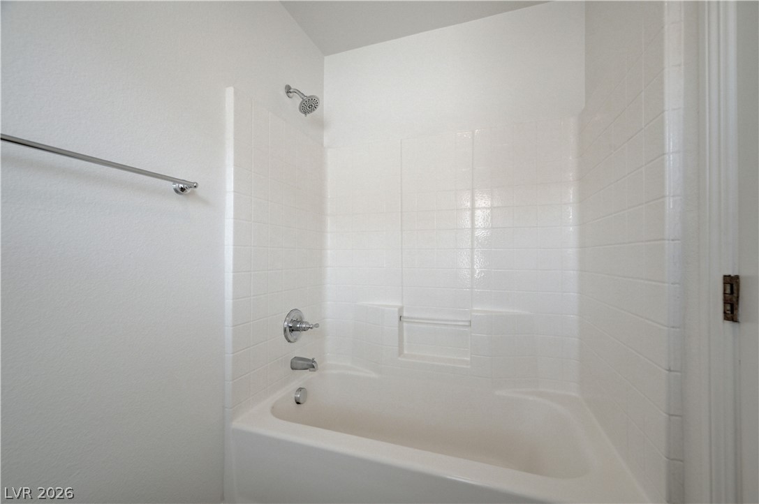 8918 Houston Ridge Avenue Las Vegas, NV 89178 - Photo 26 of 35 A pristine white tiled shower-over-tub combination offers a fresh, clean bathing experience.