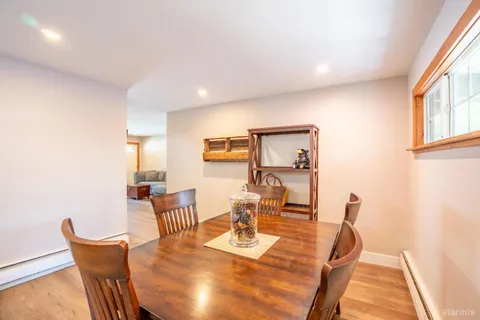 a view of a dining room with furniture a rug and wooden floor
