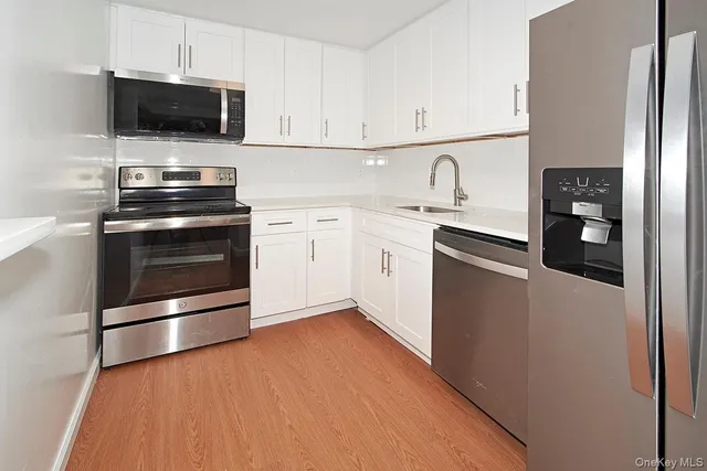 a kitchen with stainless steel appliances a stove a microwave sink and cabinets