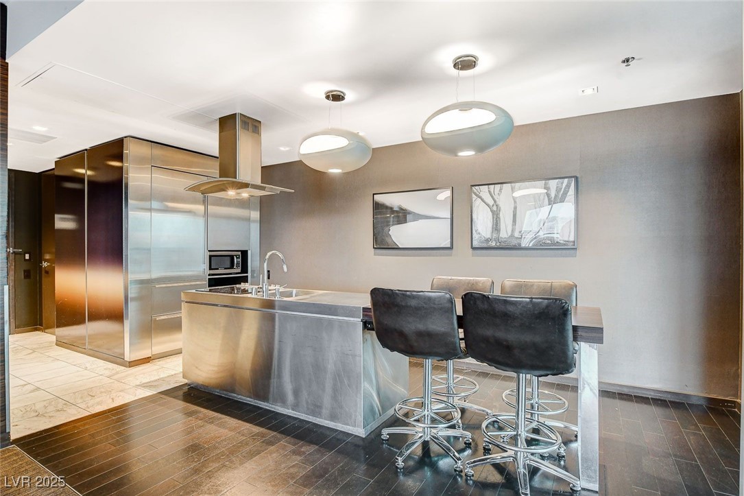 4381 West Flamingo Road, Unit 2202 Las Vegas, NV 89103 - Photo 13 of 40 Kitchen with modern cabinets, island range hood, pendant lighting, and light wood-type flooring