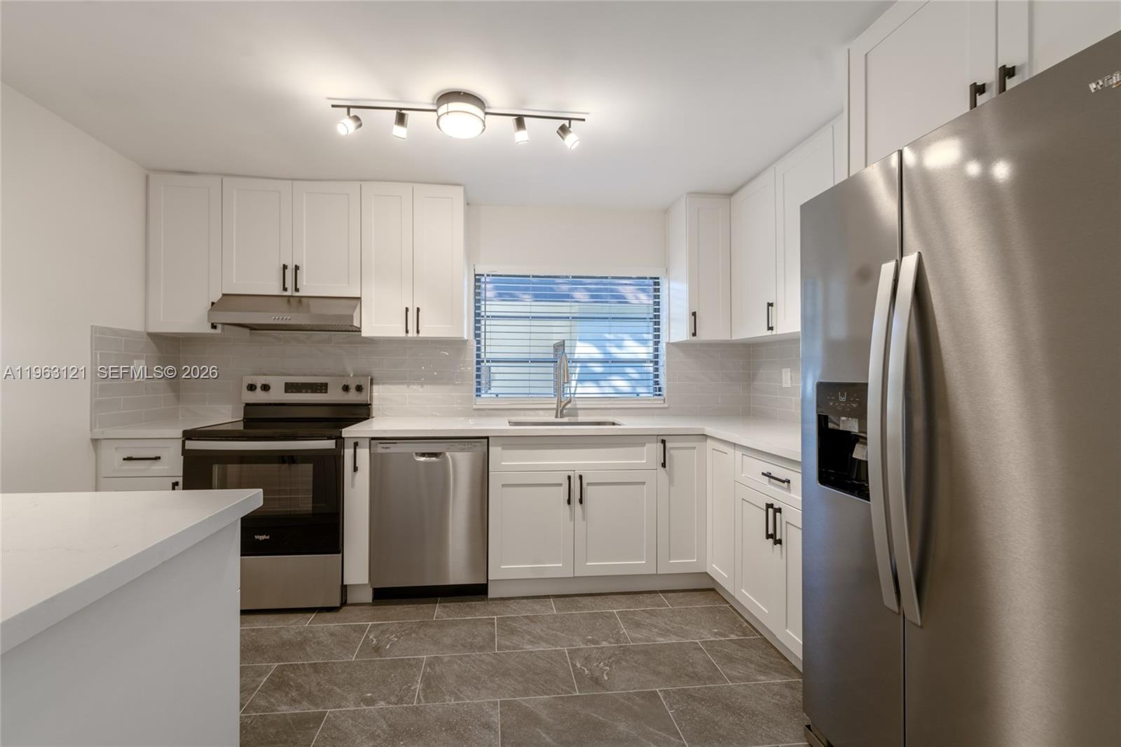 1631 Southwest 21st Street Miami, FL 33145 - Photo 11 of 58 a kitchen with granite countertop a refrigerator stove top oven and cabinets