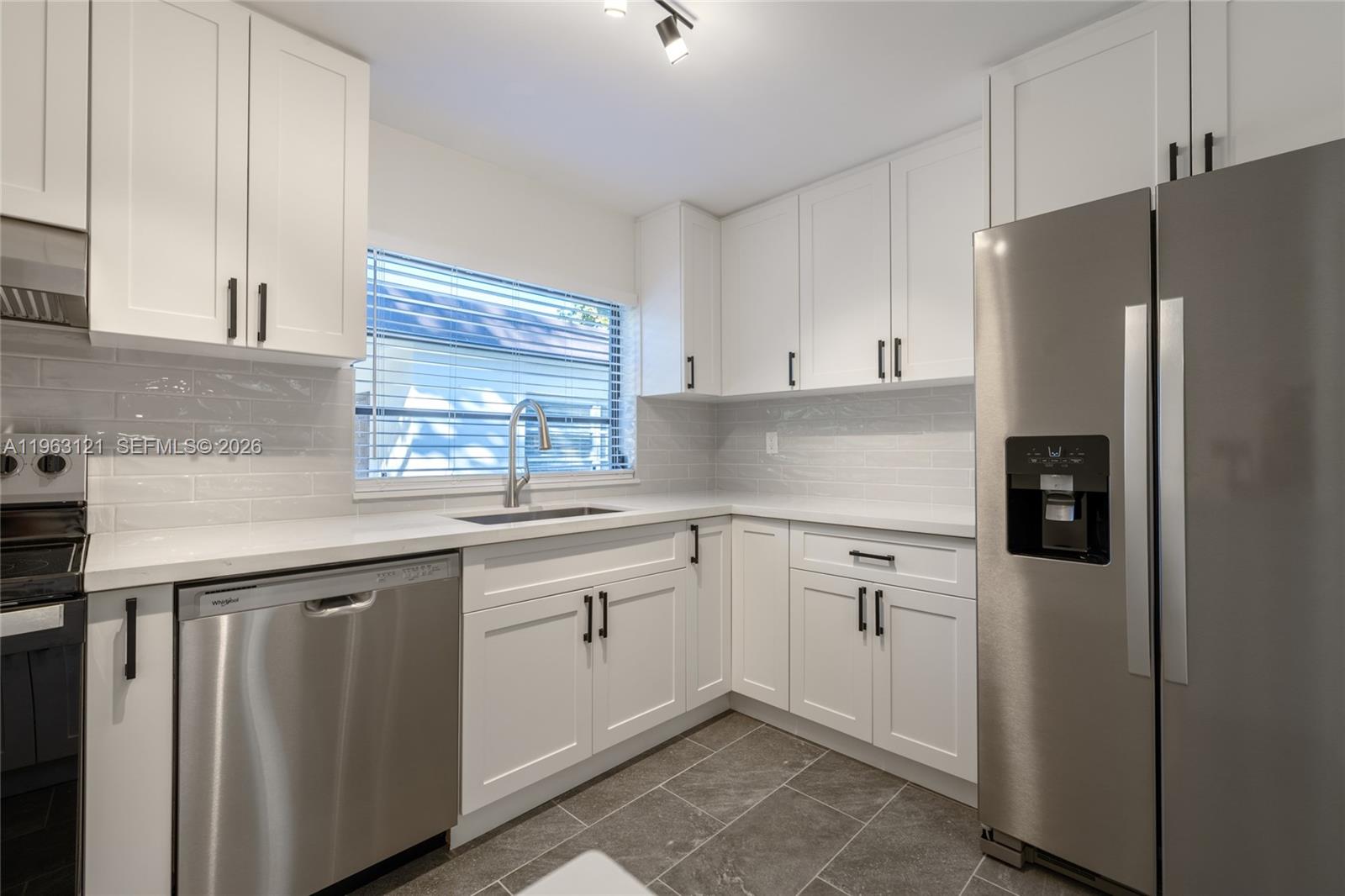 1631 Southwest 21st Street Miami, FL 33145 - Photo 12 of 58 a kitchen with granite countertop white cabinets and refrigerator