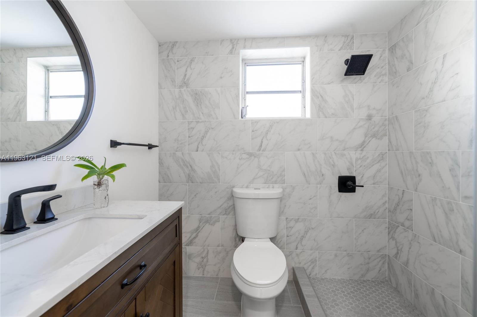 1631 Southwest 21st Street Miami, FL 33145 - Photo 24 of 58 a bathroom with a granite countertop toilet sink and mirror