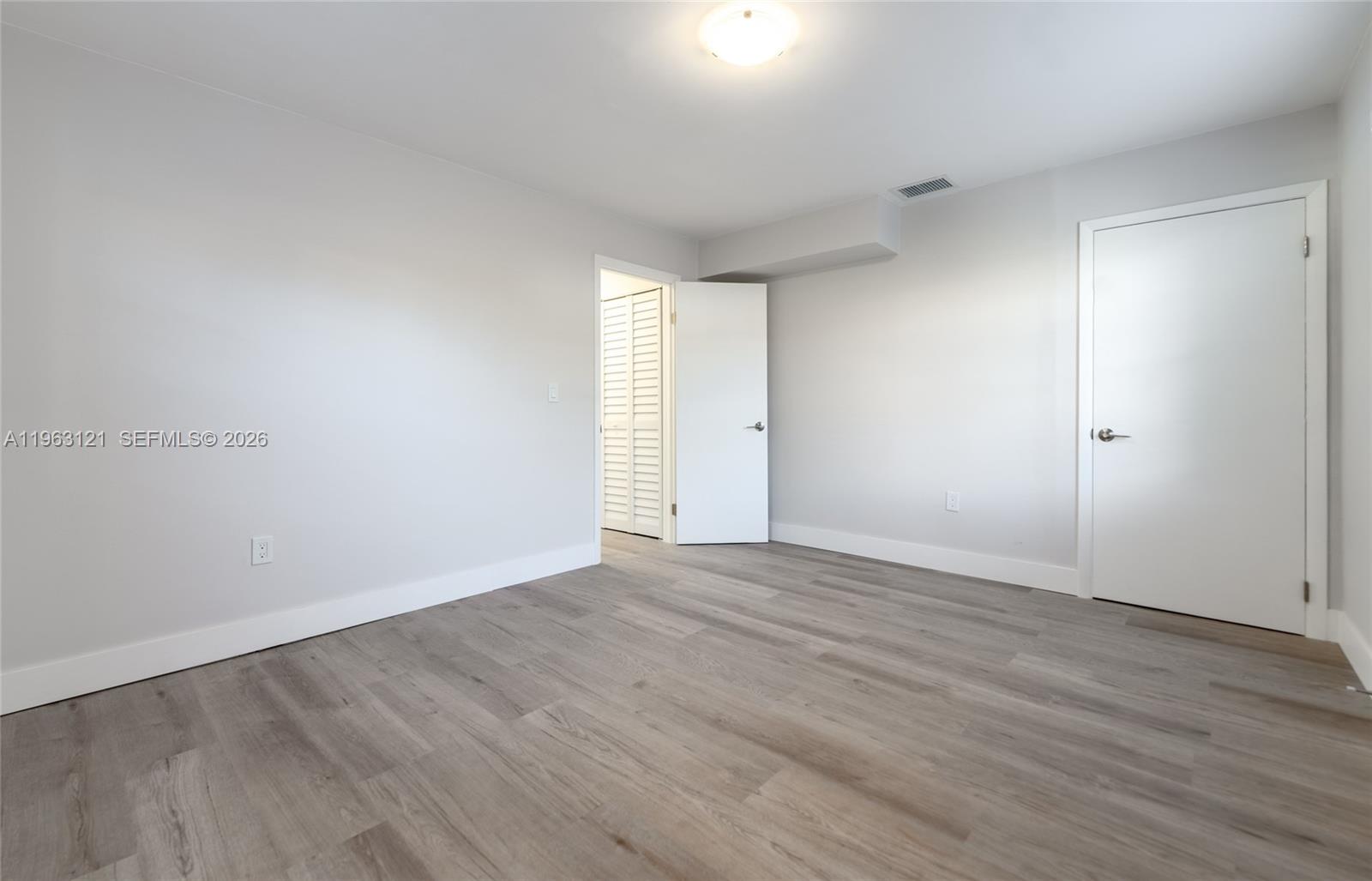 1631 Southwest 21st Street Miami, FL 33145 - Photo 39 of 58 a view of an empty room with wooden floor and a window