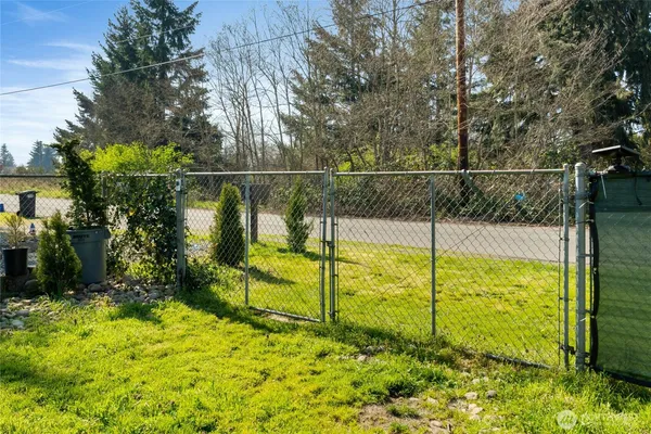 a backyard of a house with a large tree and wooden fence