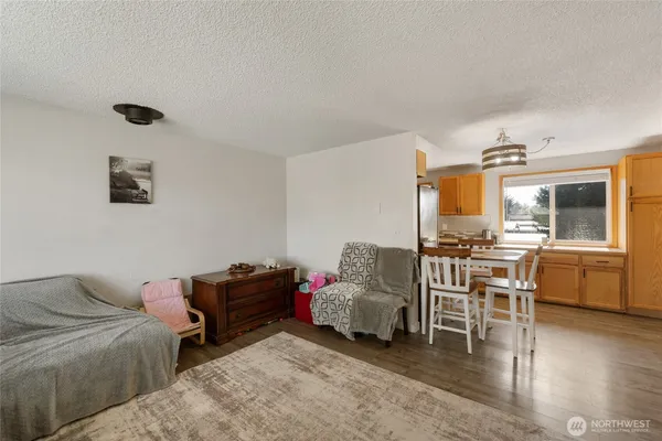 a dining room with wooden floor a chandelier a wooden table and chairs