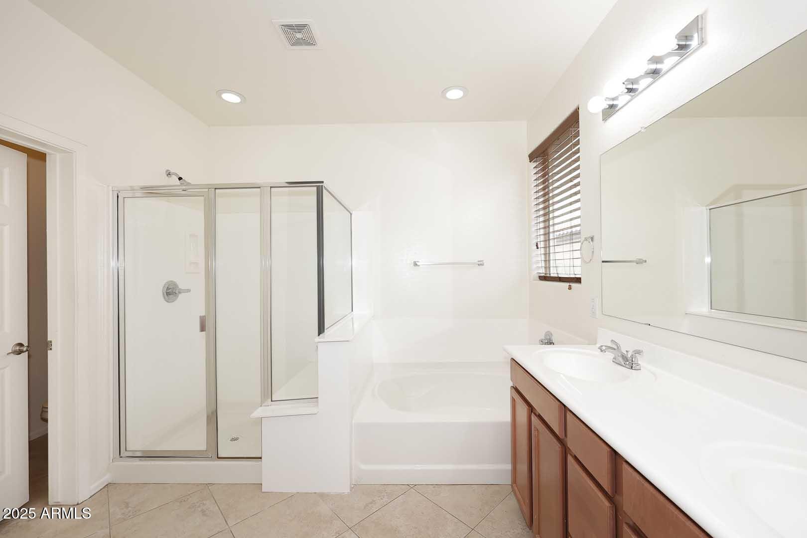 11020 East Shepperd Avenue Mesa, AZ 85212 - Photo 27 of 37 a bathroom with a double vanity sink a mirror and a bathtub