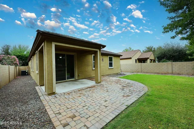 a view of a house with backyard and sitting area