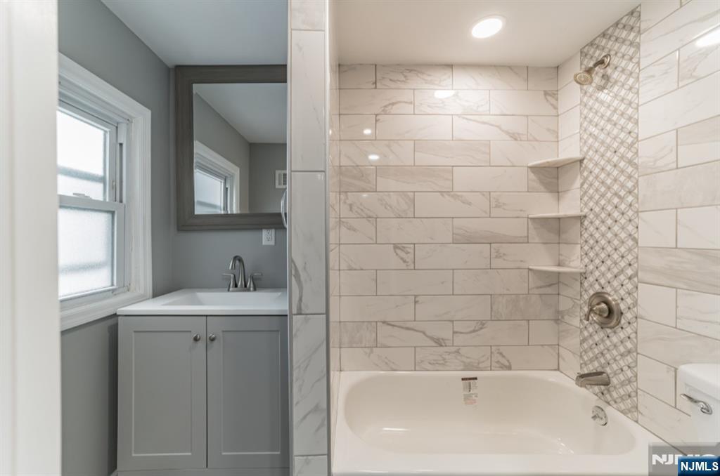 15 South Prospect Street, Unit B Verona, NJ 07044 - Photo 9 of 15 a bathroom with a bathtub a shower a sink and a window