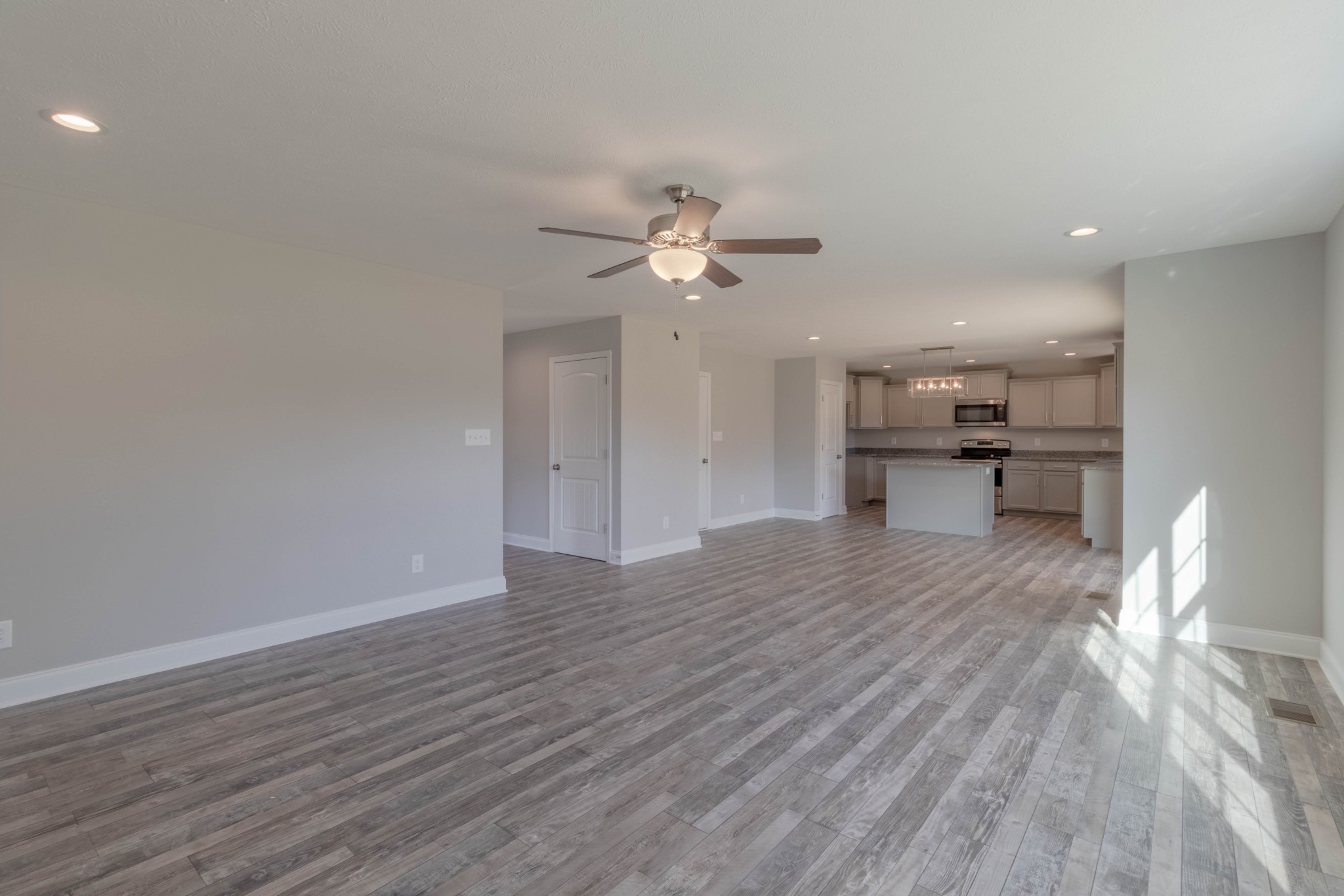 1688 Rains Road Clarksville, TN 37042 - Photo 6 of 32 a view of an empty room with a kitchen and wooden floor