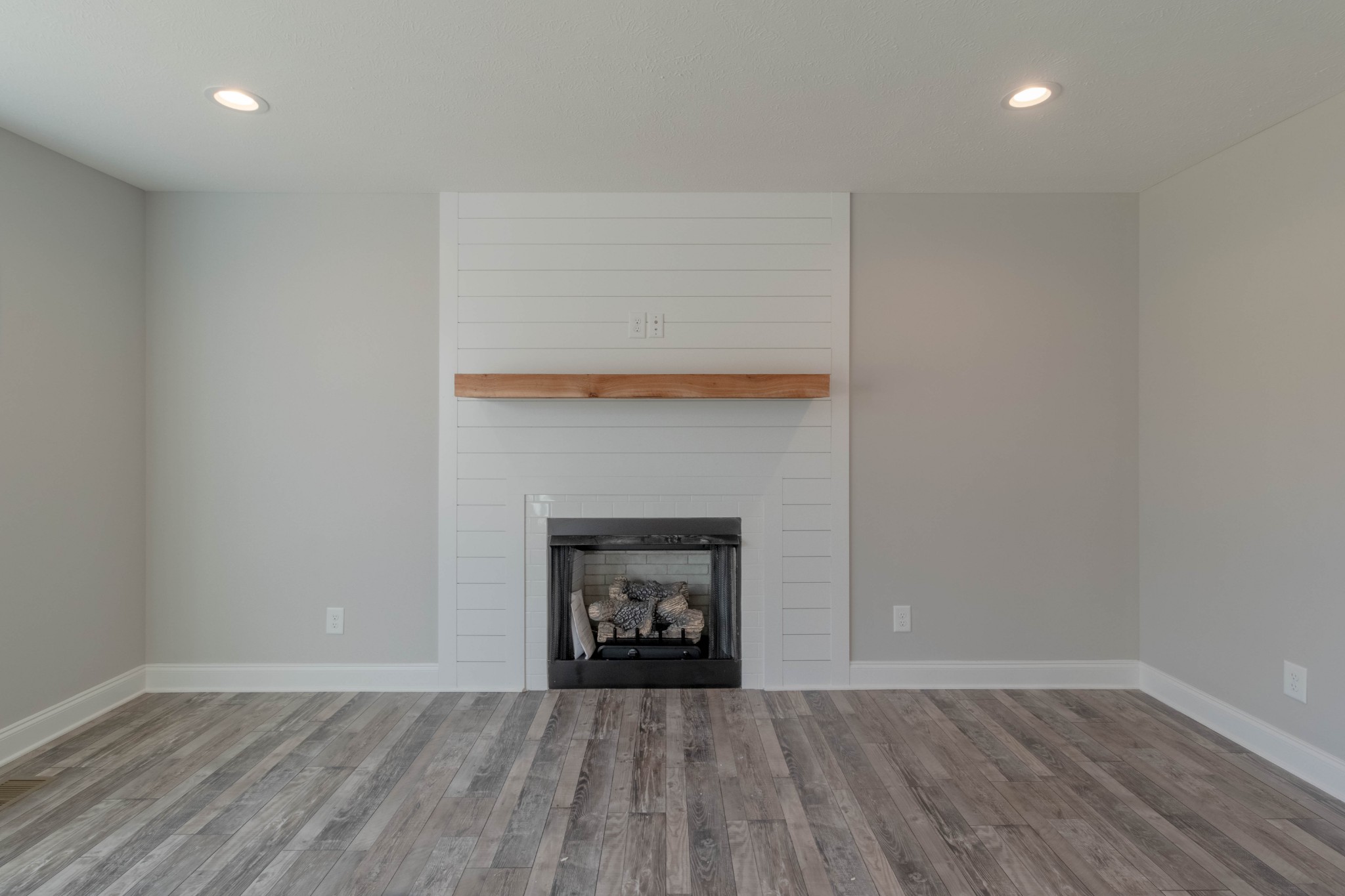 1688 Rains Road Clarksville, TN 37042 - Photo 7 of 32 an empty room with wooden floor and fireplace