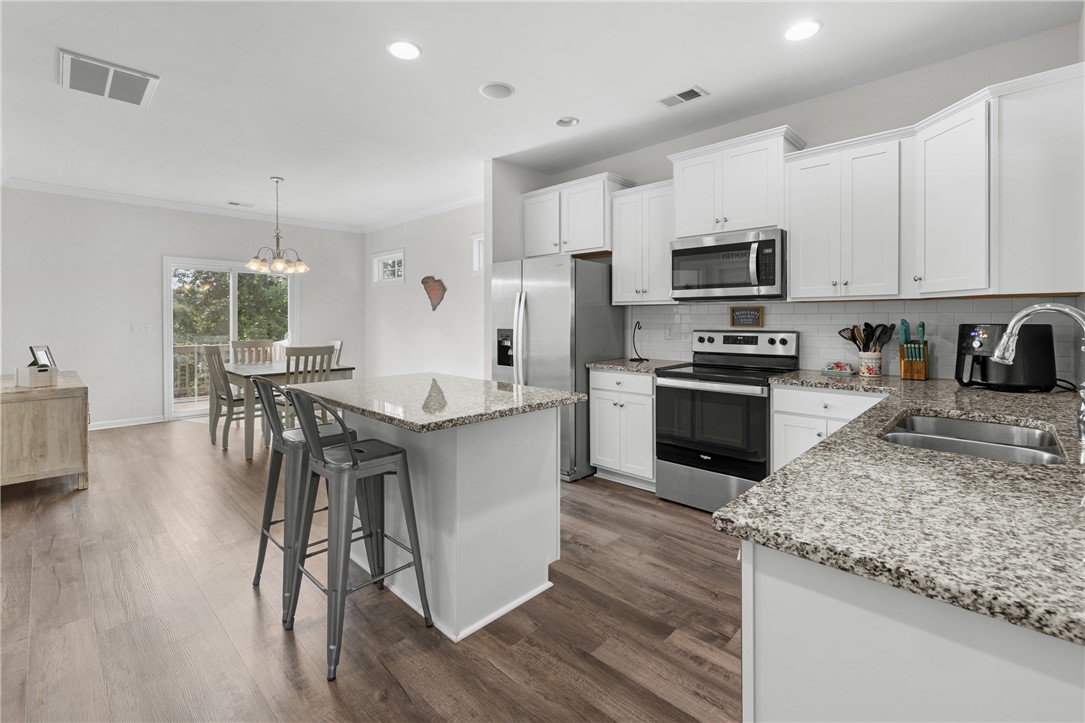 768 Rocky Ridge Circle Seneca, SC 29678 - Photo 10 of 30 Granite counters and stainless steel appliances create a sophisticated culinary workspace, flowing into a bright dining area.