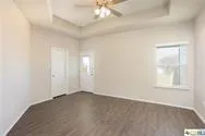 an empty room with windows and fan