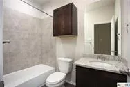 a bathroom with a granite countertop sink toilet and shower