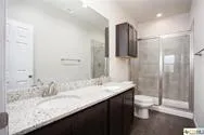 a bathroom with a granite countertop sink a toilet and shower