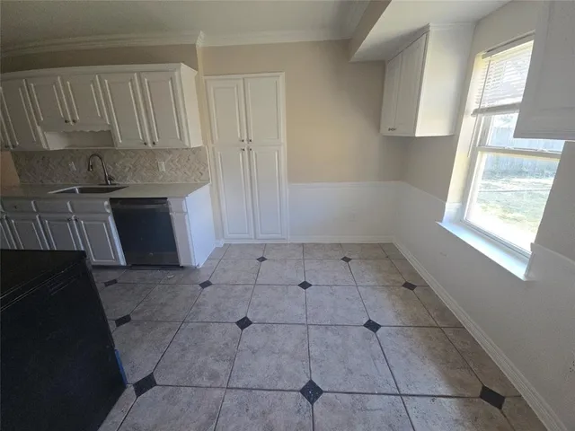 a kitchen with a refrigerator sink and cabinets
